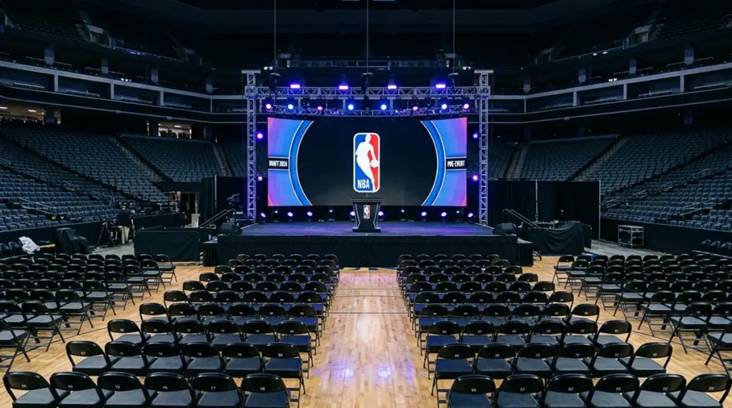 Empty NBA arena stage set up for the draft with a podium and team logos displayed on large screens